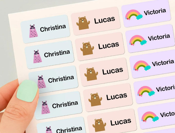 Hand som håller ett tryckt ark med färgglada namnlappar för Christina, Lucas och Victoria